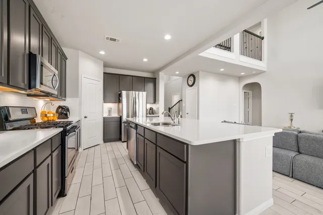 a kitchen with stainless steel appliances a sink stove and refrigerator