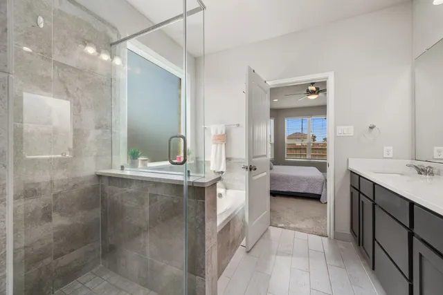 a en suite bathroom with a double vanity sink a mirror and a shower