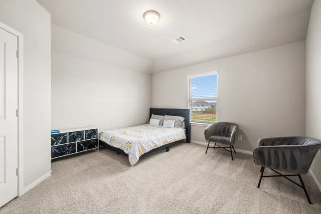 a bedroom with a bed and a chair