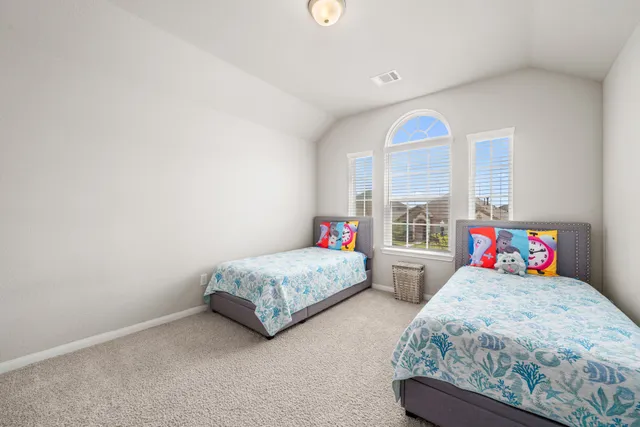 a bedroom with two beds and a large window