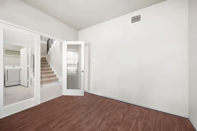a view of a hallway with wooden floor and entryway