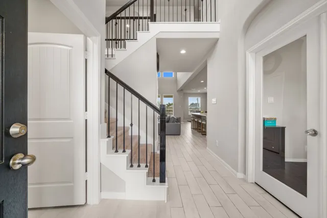a view of a hallway with wooden floor and staircase