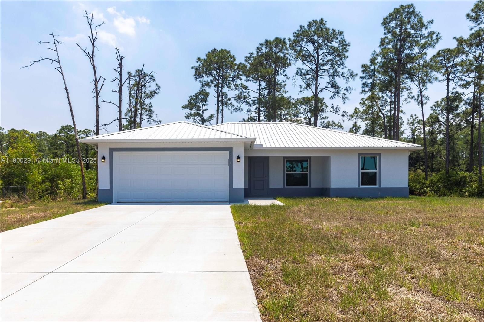 a front view of house with yard and trees in the background