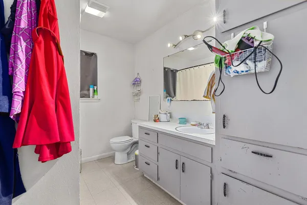 a bathroom with a sink vanity mirror and toilet
