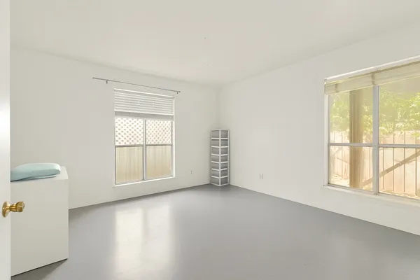 an empty room with windows and closet