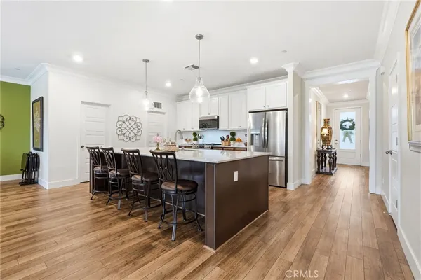 a kitchen with stainless steel appliances a dining table chairs stove and refrigerator