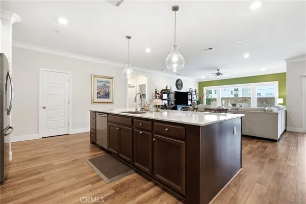 a large kitchen with kitchen island a sink stainless steel appliances and a wooden floor