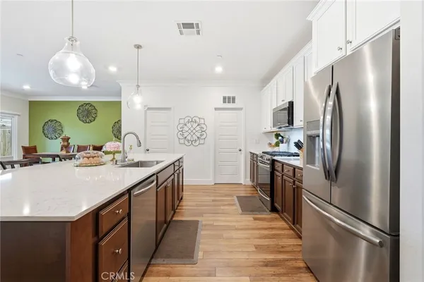 a kitchen with stainless steel appliances granite countertop a sink a stove and a refrigerator