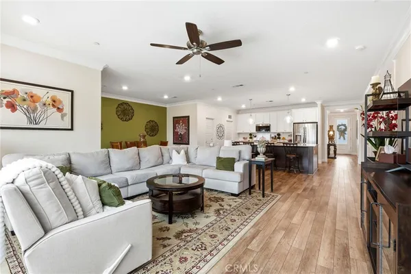 a living room with furniture kitchen view and a chandelier