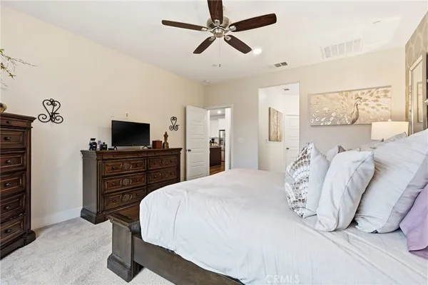a bedroom with a bed and a tv on the dresser