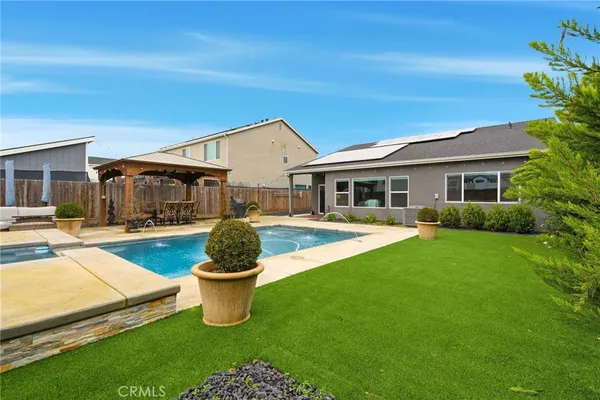 a view of a house with swimming pool and a yard