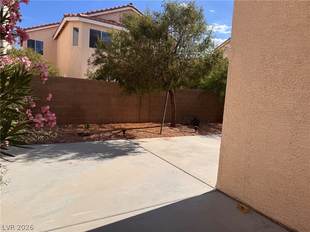 8937 Austin Ridge Avenue Las Vegas, NV 89178 - Photo 14 of 22 A spacious concrete patio awaits outdoor enjoyment, bordered by a privacy wall and mature landscaping.