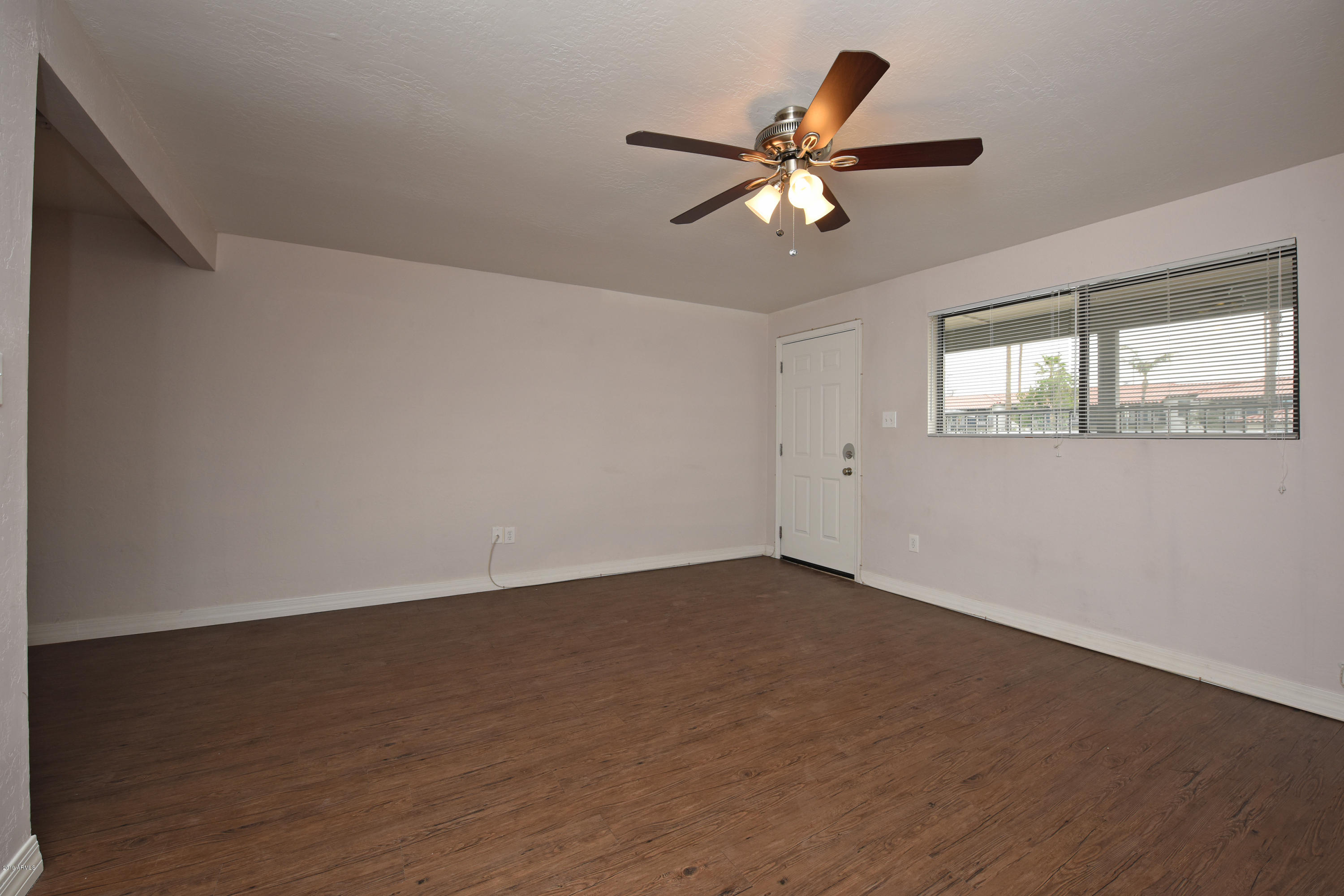 502 East Mariposa Street, Unit 101 Phoenix, AZ 85012 - Photo 12 of 24 a view of an empty room with wooden floor and a window