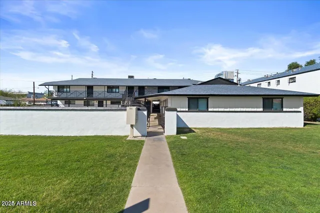 a view of a house with a big yard potted plants and large tree