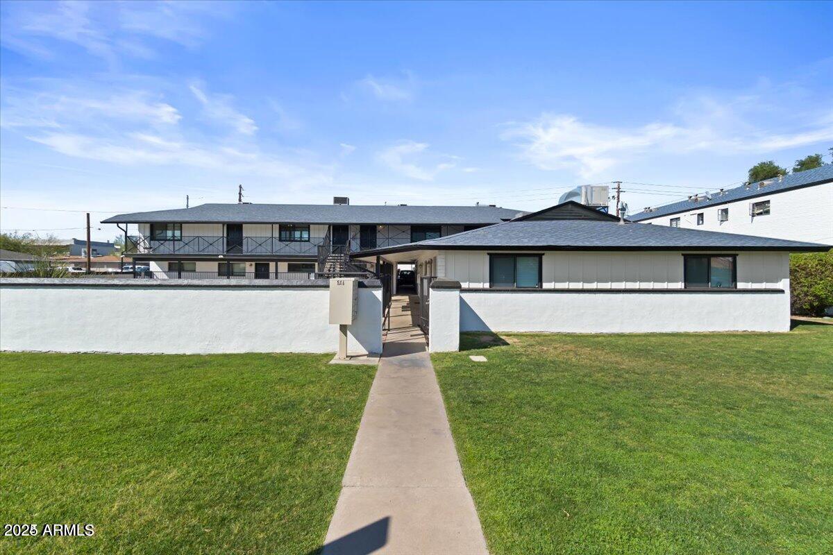 502 East Mariposa Street, Unit 101 Phoenix, AZ 85012 - Photo 4 of 24 a view of a house with a big yard potted plants and large tree