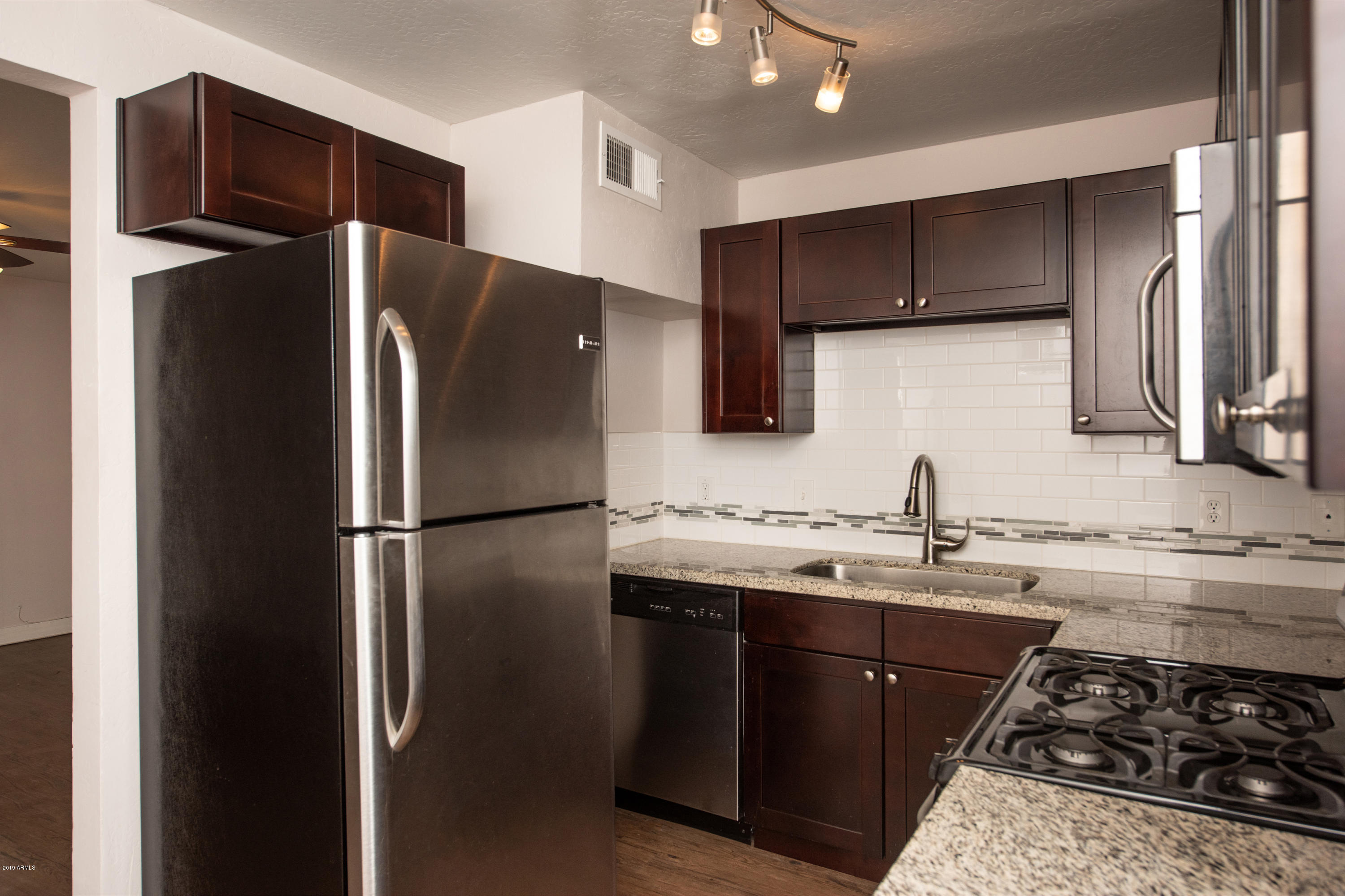 502 East Mariposa Street, Unit 101 Phoenix, AZ 85012 - Photo 5 of 24 a kitchen with stainless steel appliances granite countertop a refrigerator and a sink