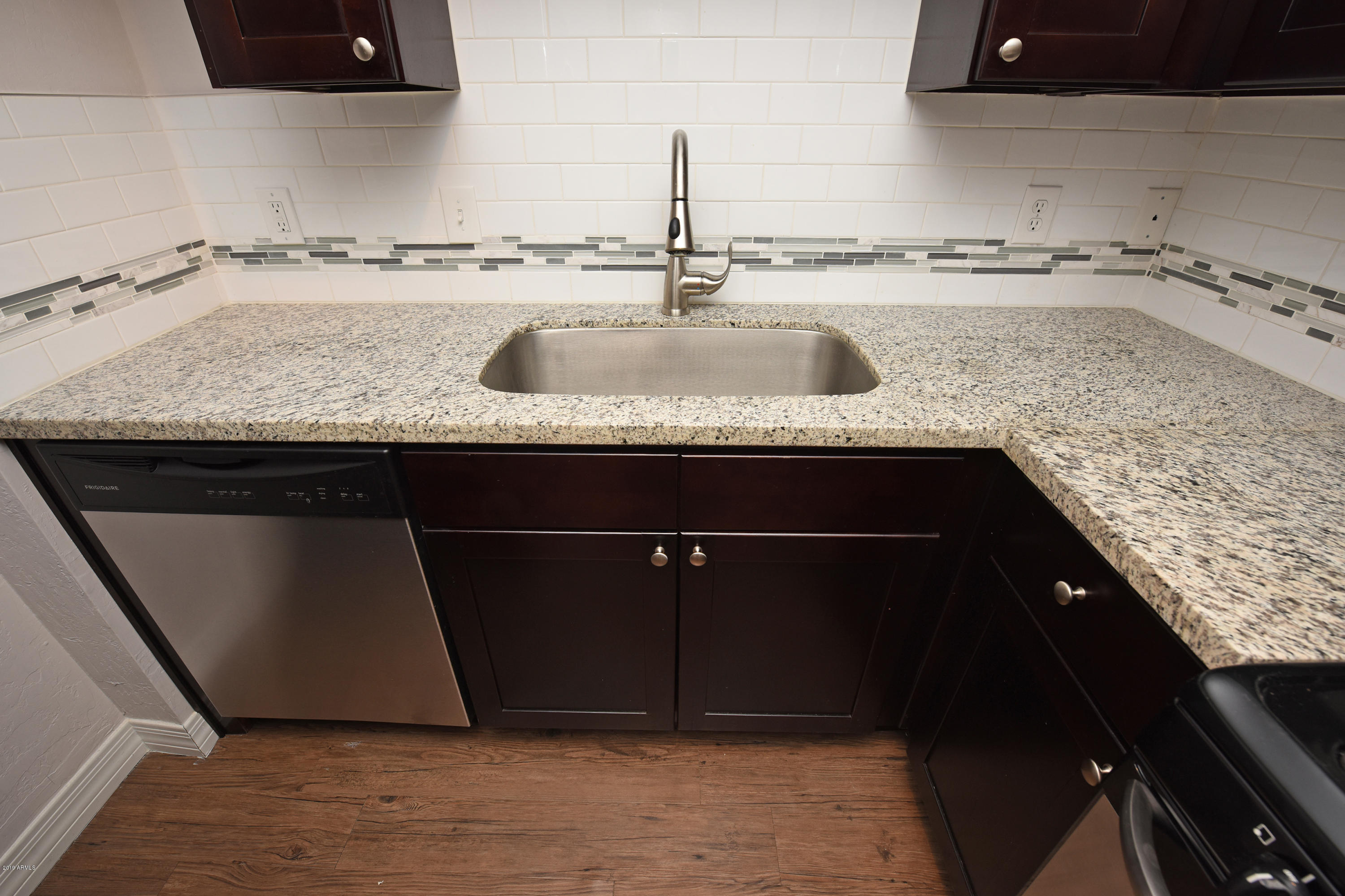 502 East Mariposa Street, Unit 101 Phoenix, AZ 85012 - Photo 6 of 24 a kitchen with granite countertop a sink and cabinets