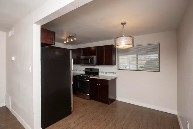 a kitchen with stainless steel appliances granite countertop a refrigerator and a stove