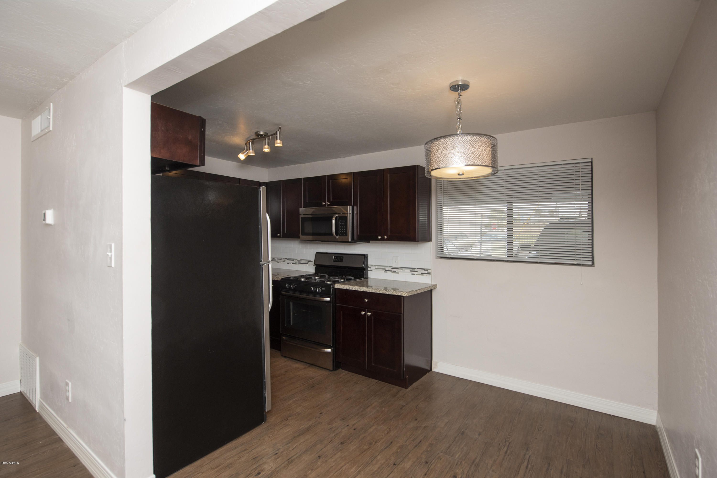 502 East Mariposa Street, Unit 101 Phoenix, AZ 85012 - Photo 9 of 24 a kitchen with stainless steel appliances granite countertop a refrigerator and a stove