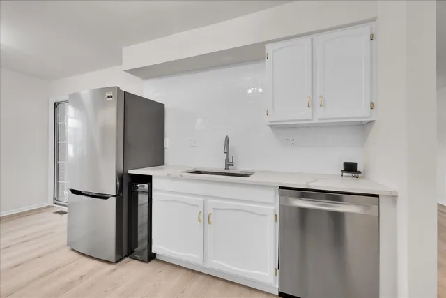 a kitchen with a refrigerator sink and cabinets