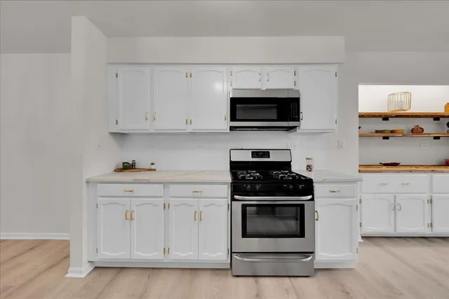 a kitchen with white cabinets and stainless steel appliances