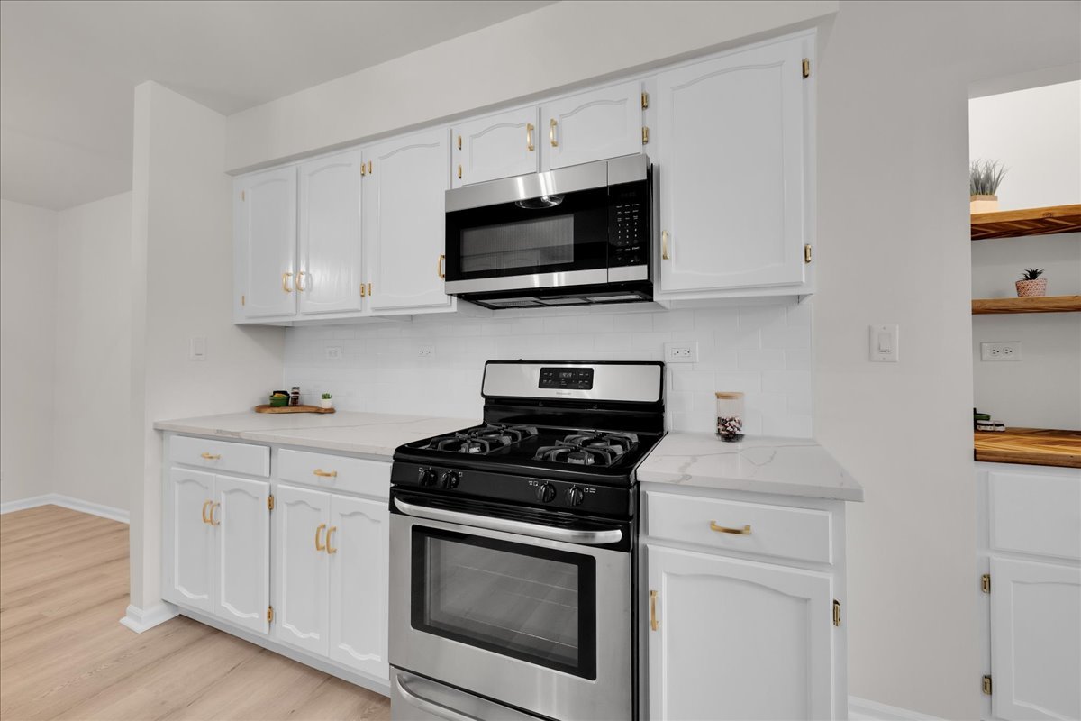 1785 Grosvenor Circle, Unit A Wheaton, IL 60189 - Photo 14 of 37 a kitchen with stainless steel appliances granite countertop grey cabinets a stove a sink and a microwave