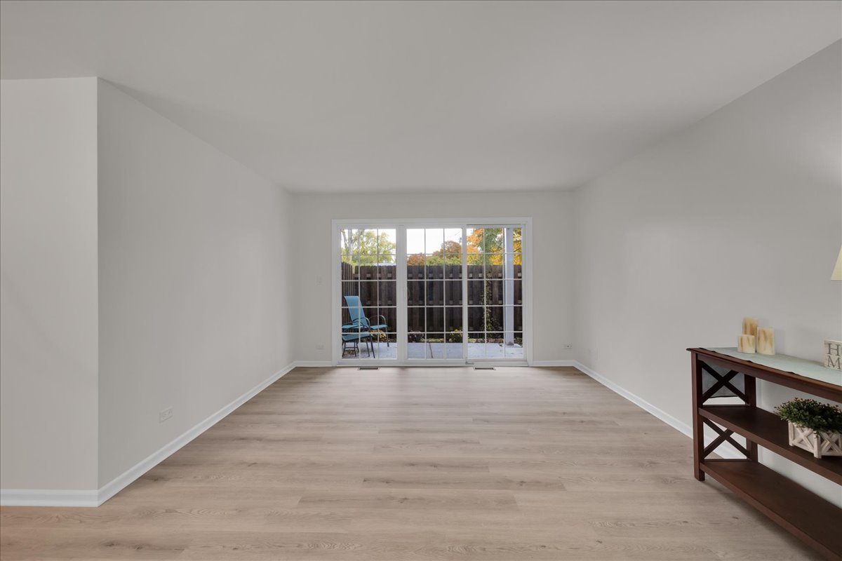 1785 Grosvenor Circle, Unit A Wheaton, IL 60189 - Photo 15 of 37 a view of an empty room with wooden floor and a window