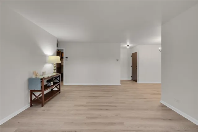 a view of an empty room with stairs and a window