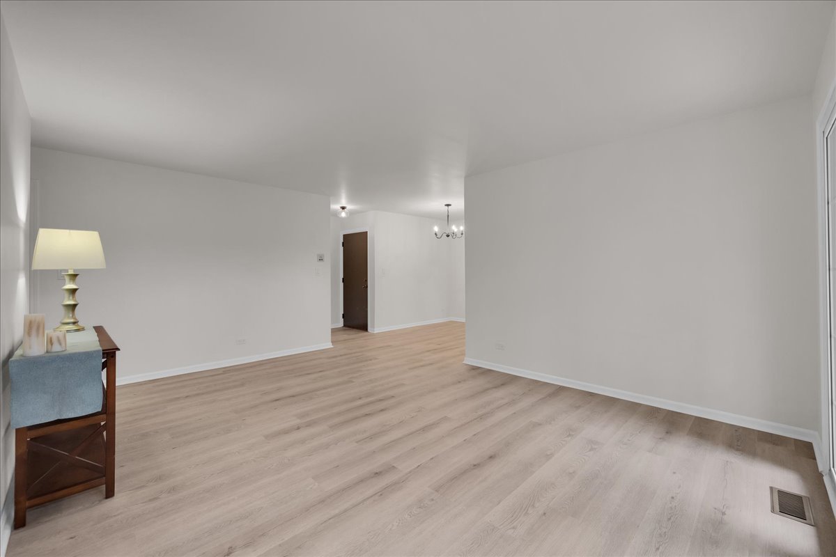 1785 Grosvenor Circle, Unit A Wheaton, IL 60189 - Photo 18 of 37 a view of an empty room and wooden floor