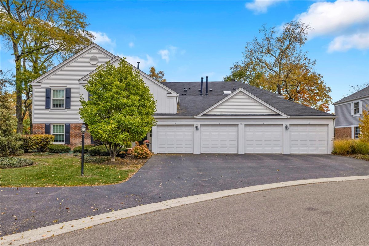 1785 Grosvenor Circle, Unit A Wheaton, IL 60189 - Photo 2 of 37 a view of a grey house with a yard and large tree