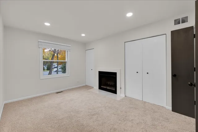 a view of an empty room with a fireplace and a window