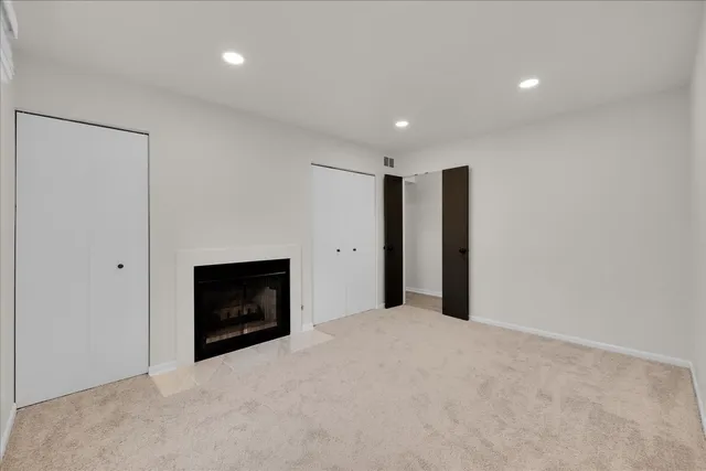 a view of an empty room with a fireplace and a window