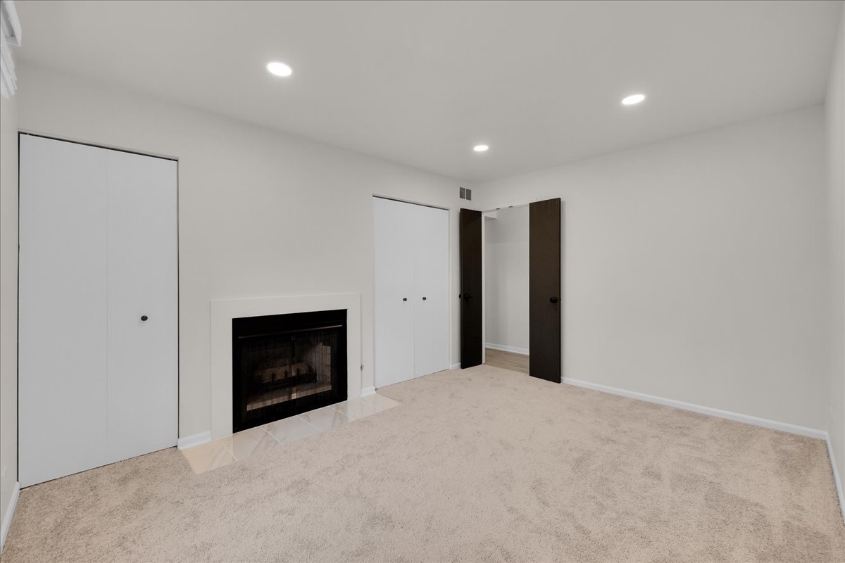1785 Grosvenor Circle, Unit A Wheaton, IL 60189 - Photo 25 of 37 a view of an empty room with a fireplace and a window