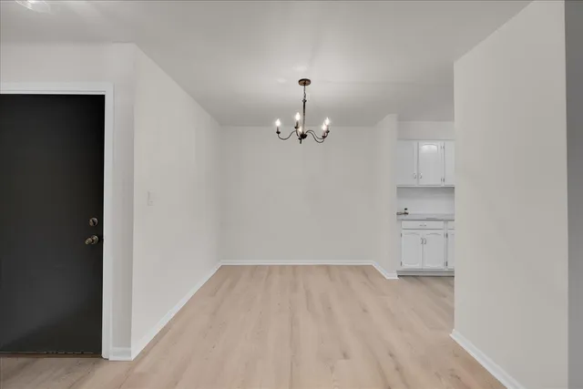 a view of a room with wooden floor and kitchen space