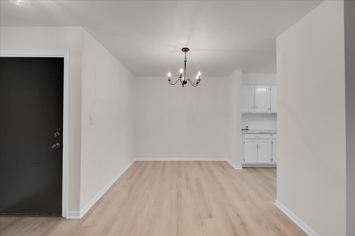 1785 Grosvenor Circle, Unit A Wheaton, IL 60189 - Photo 5 of 37 a view of a room with wooden floor and kitchen space