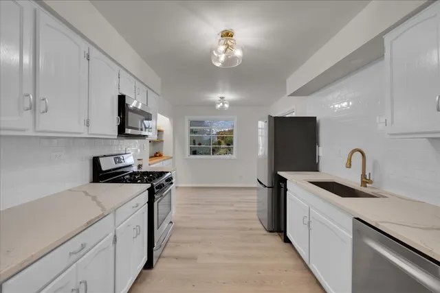 a kitchen with stainless steel appliances granite countertop a sink stove and refrigerator