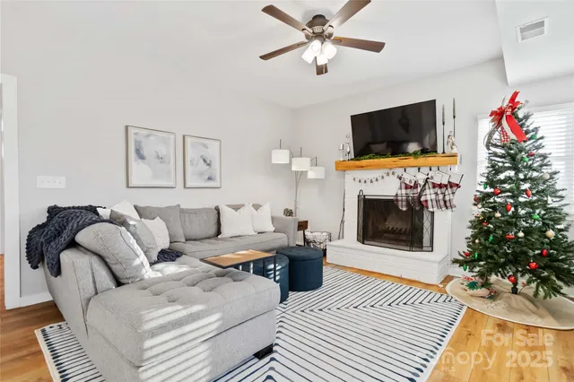 a living room with furniture a flat screen tv and a fireplace