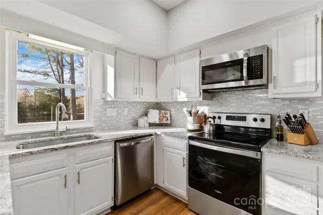 a kitchen with stainless steel appliances granite countertop a stove and a sink