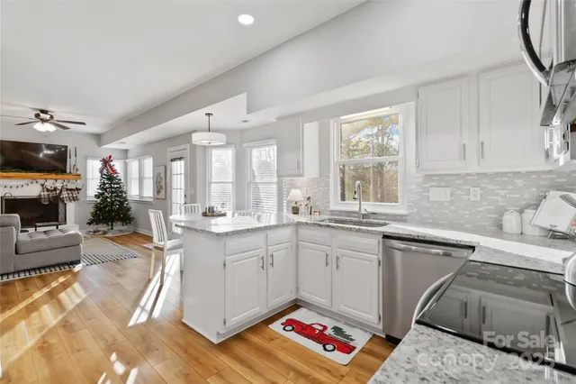 a kitchen with granite countertop a sink stainless steel appliances and cabinets