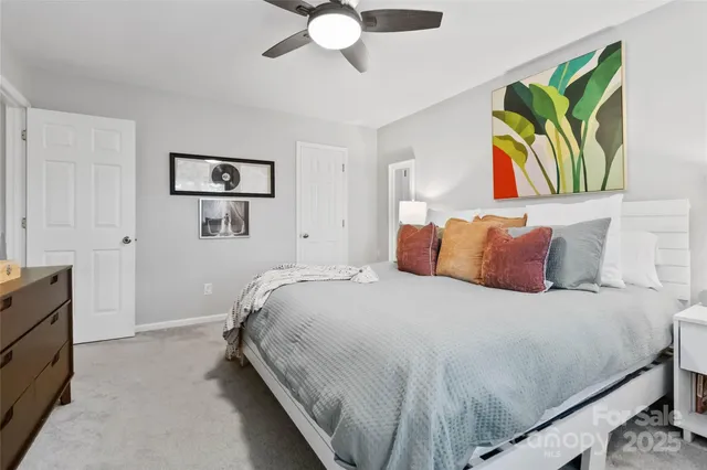 a bedroom with a bed and a painting on the wall