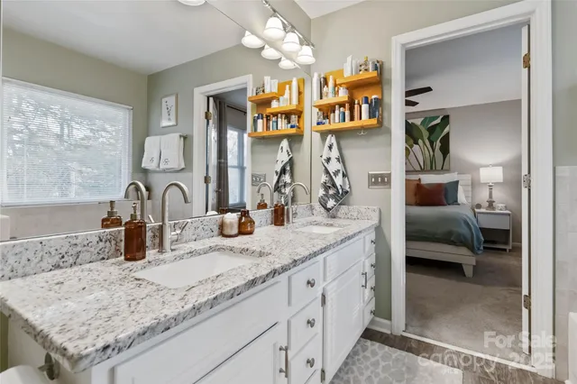 a en suite bathroom with a granite countertop sink and a mirror