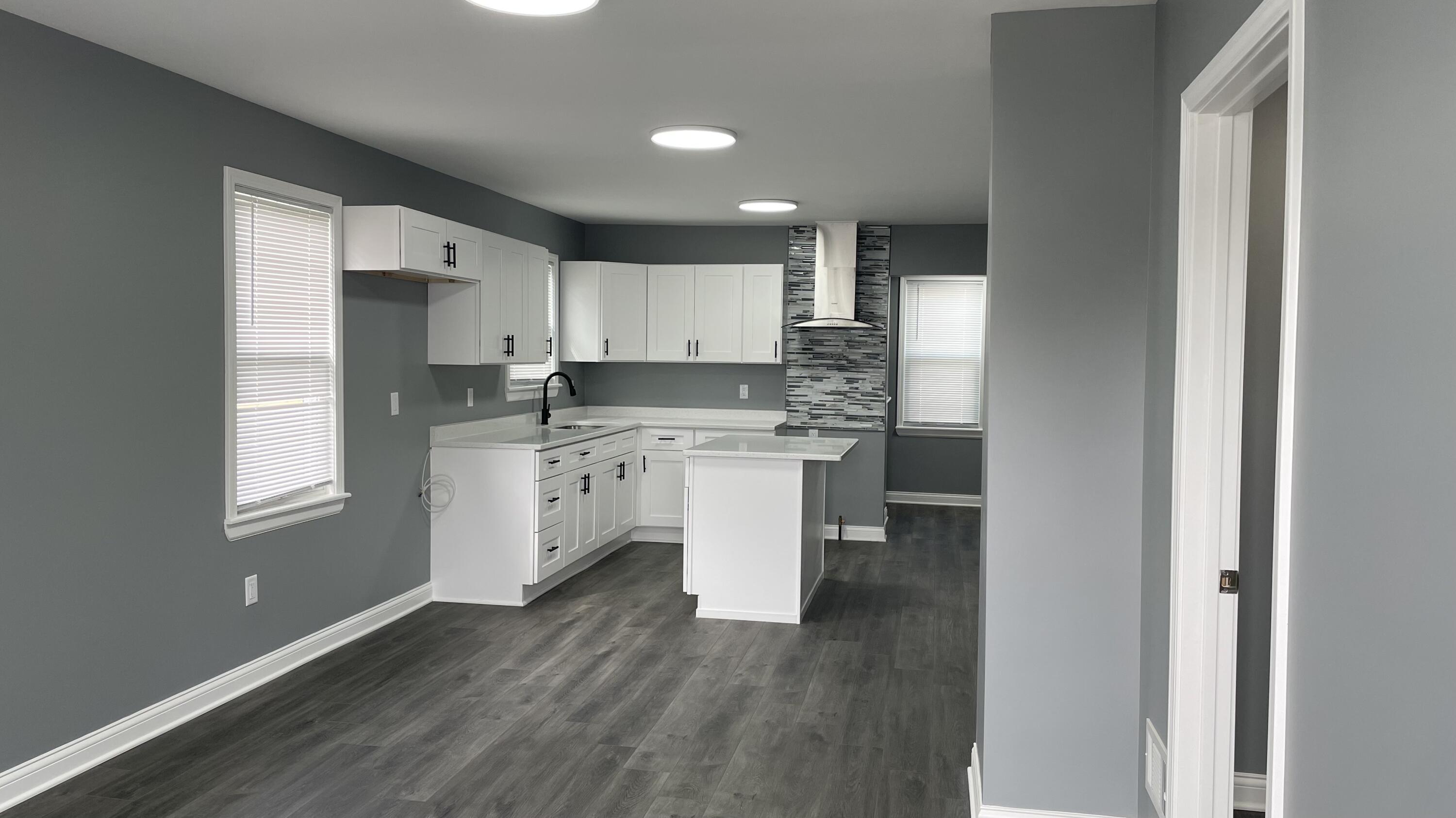 3362 Virginia Street Gary, IN 46409 - Photo 4 of 29 a kitchen with kitchen island granite countertop a sink cabinets and wooden floor