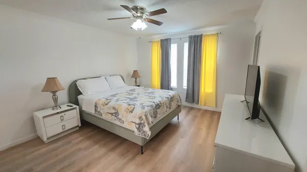 a bedroom with a bed dresser and a window