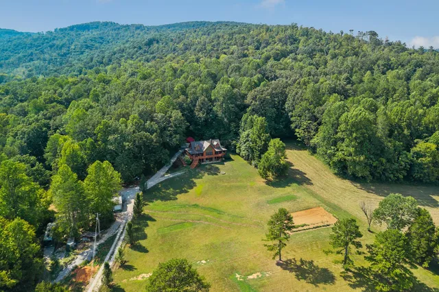 a view of a green field with a house in the background