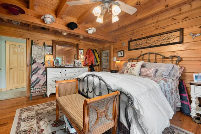 a living room with stainless steel appliances furniture a rug kitchen view and a large window