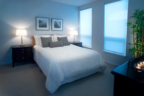 a bedroom with a bed and a potted plant