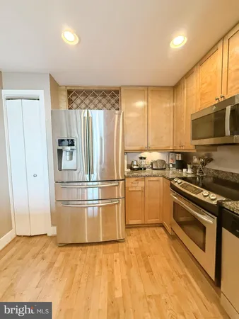 a kitchen with granite countertop a refrigerator and a stove top oven