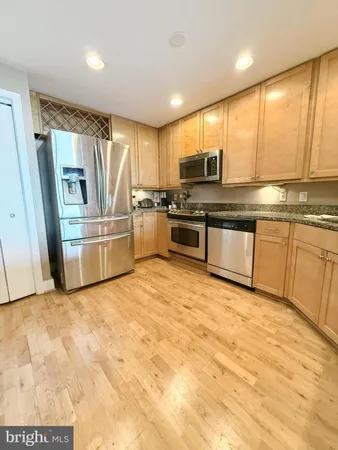 a view of kitchen with stainless steel appliances granite countertop a stove and a sink