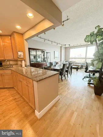 a large white kitchen with lots of counter top space and living room
