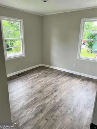 a view of room with window and wooden floor